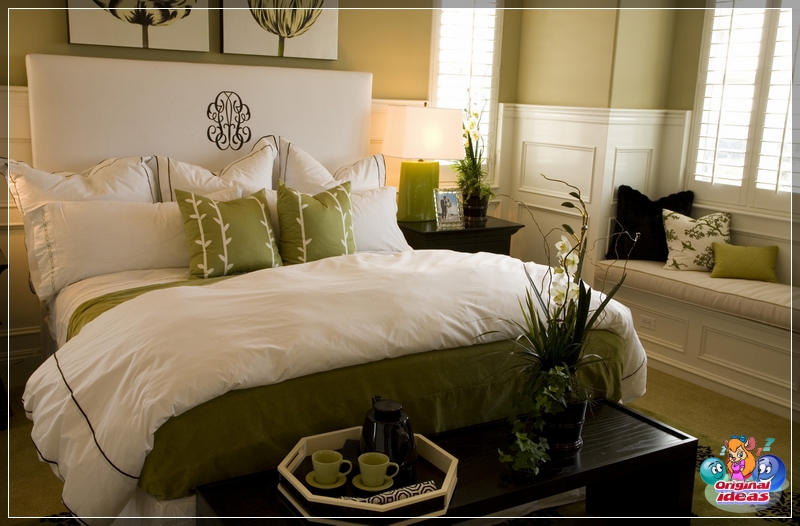 Bett im Schlafzimmer mit Decke und Kissen in Weiß und Grün