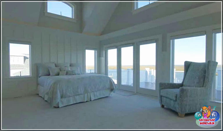 Вялікая галоўная спальня з балконам і высокімі столямі з выглядам на заліў