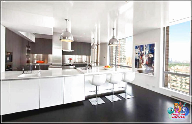 Белая сучасная кухня ў шафе з бетоннай падлогай і храмаванымі падвеснымі свяцільнямі