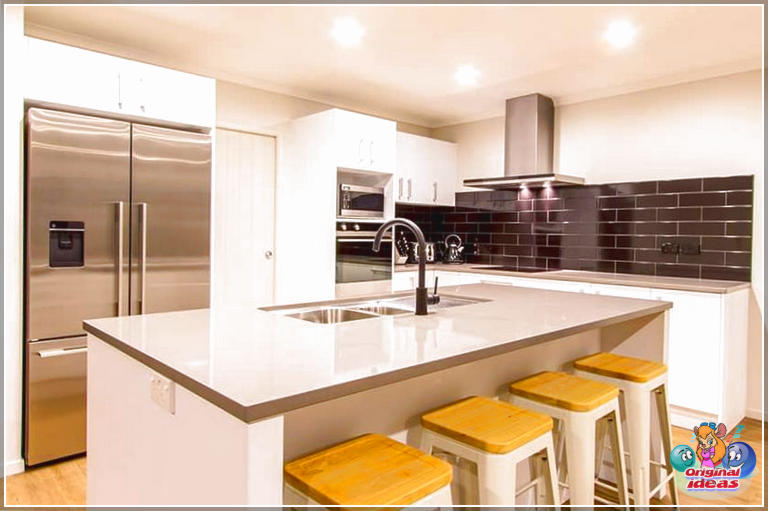 Сучасная кухня ў белым шафе з чорнай цаглянай падкладкай і шэрым ламінатным сустрэчным востравам